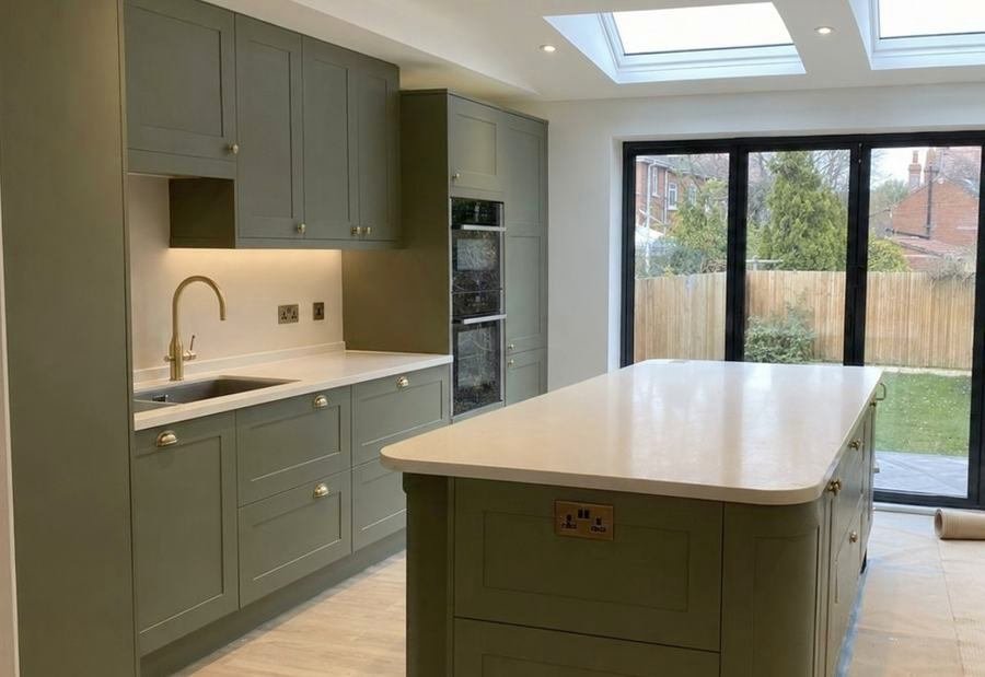 Sage green shaker kitchen with a large island and roof lights above