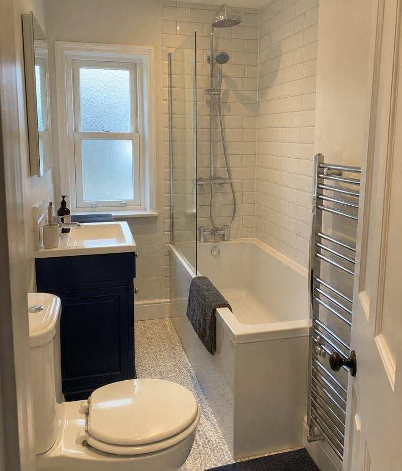 Loft ensuite with a shower over the bath and a fitted vanity