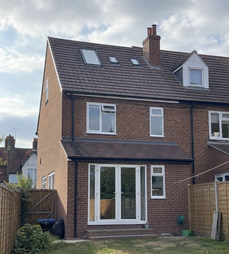 Rear dormer conversion on a brick semi with new windows across the back