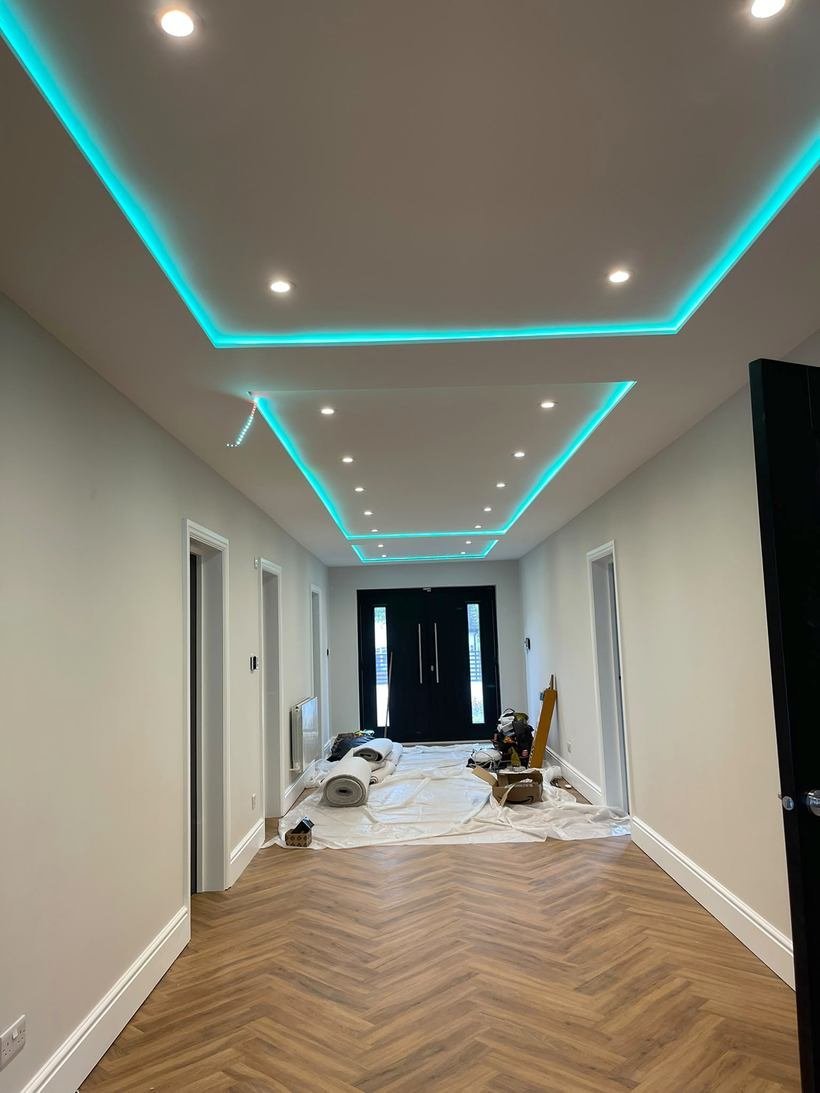 Hallway with a drop ceiling, colour changing cove lighting and herringbone flooring