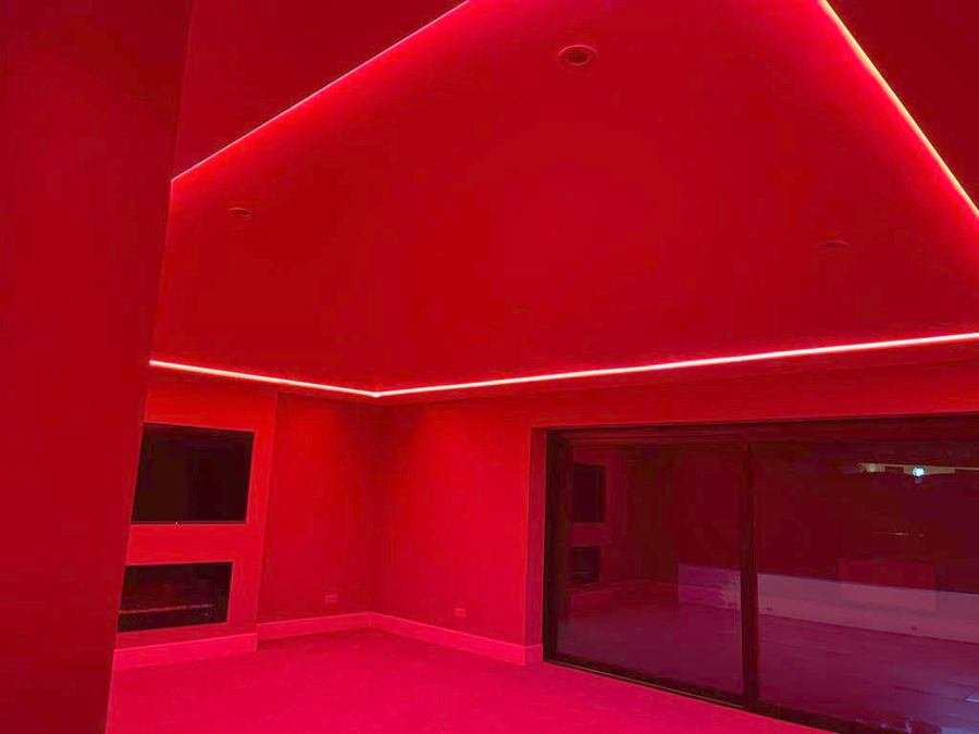 Living room with a media wall, inset fire and colour changing cove lighting